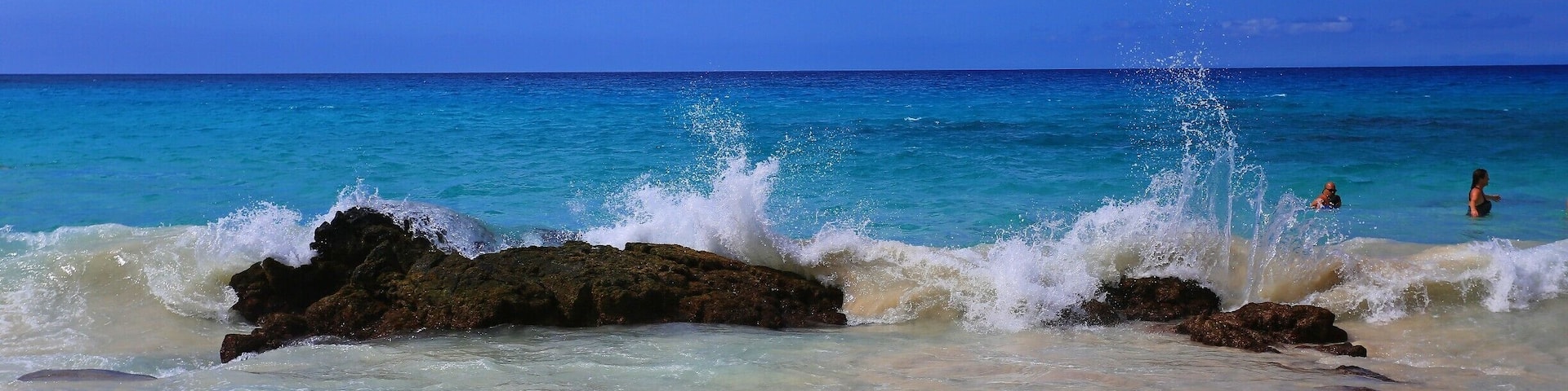 #blue
50 Shades of Blue - Manini'owali Beach at Kua Bay, part of Kekaha Kai State Park, is another of the very pretty Hawaii Big Island beaches, with fine white sand that slopes gently to the beautiful clear turquoise water. The swimming here is awesome when the ocean is calm, and there can be some decent snorkeling along the rocky outcroppings at either end of the beach. During certain times of the year, particularly the summer months, the beautiful soft sand covers the entire beach from north to south. More lava rocks become exposed in the winter months as sand is carried out with the surf. Be aware of those rocks in the shallows when boogie boarding or body surfing. This is a good place to have water shoes to navigate across the rocks. Manini'owali Beach is one of the nicer Big Island beaches that is easy to reach from Kailua-Kona. You can practically drive right to the beach, and some days it seems everyone on the Big Island knows it! If you arrive later in the day, parking can be a little crazy, especially on weekends. As you approach the beach you may see cars lined up down the road. You may have to walk down the road a bit but don't worry; there's plenty of room on the beach! There is a rocky shoreline trail at the northern end of the beach that leads to another of our favorite Hawaii beaches, spectacular Kikaua Beach to the north. The trail winds through a lava field and across a coral beach less than a mile to scenic Kikaua Point.