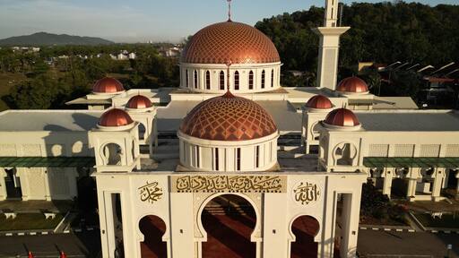 Sungai Petani, Kedah, Malaysia – July 14, 2025 - Aerial morning view of mosque located in Bandar Perdana, surrounded by hills and residential housing area. Editorial use only.