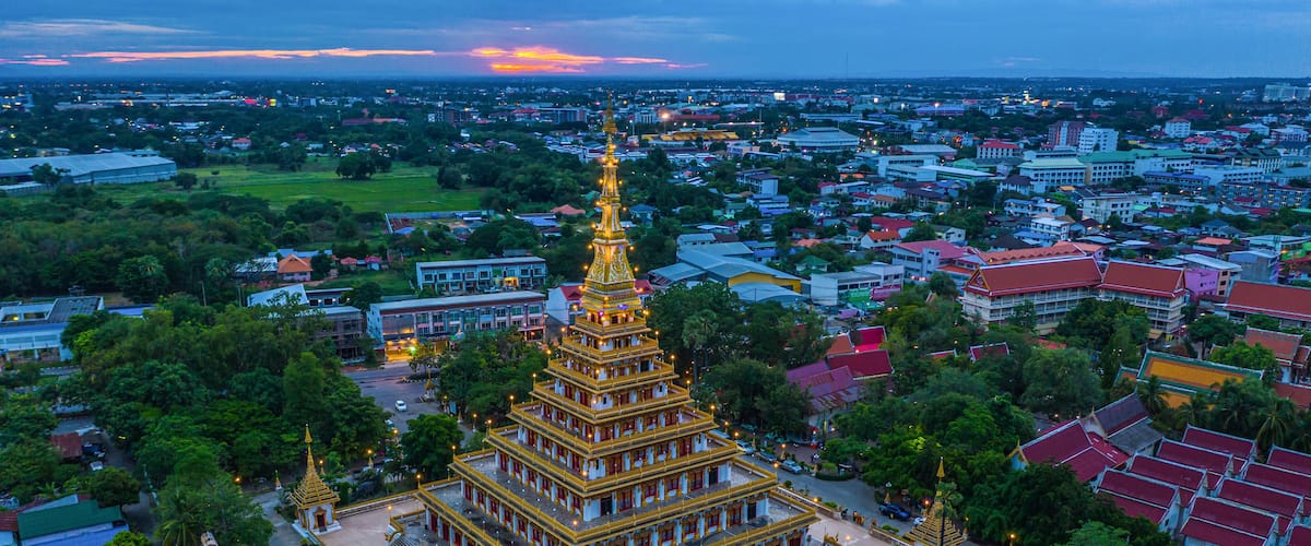 A golden pagoda surrounded by a cityscape at dusk.