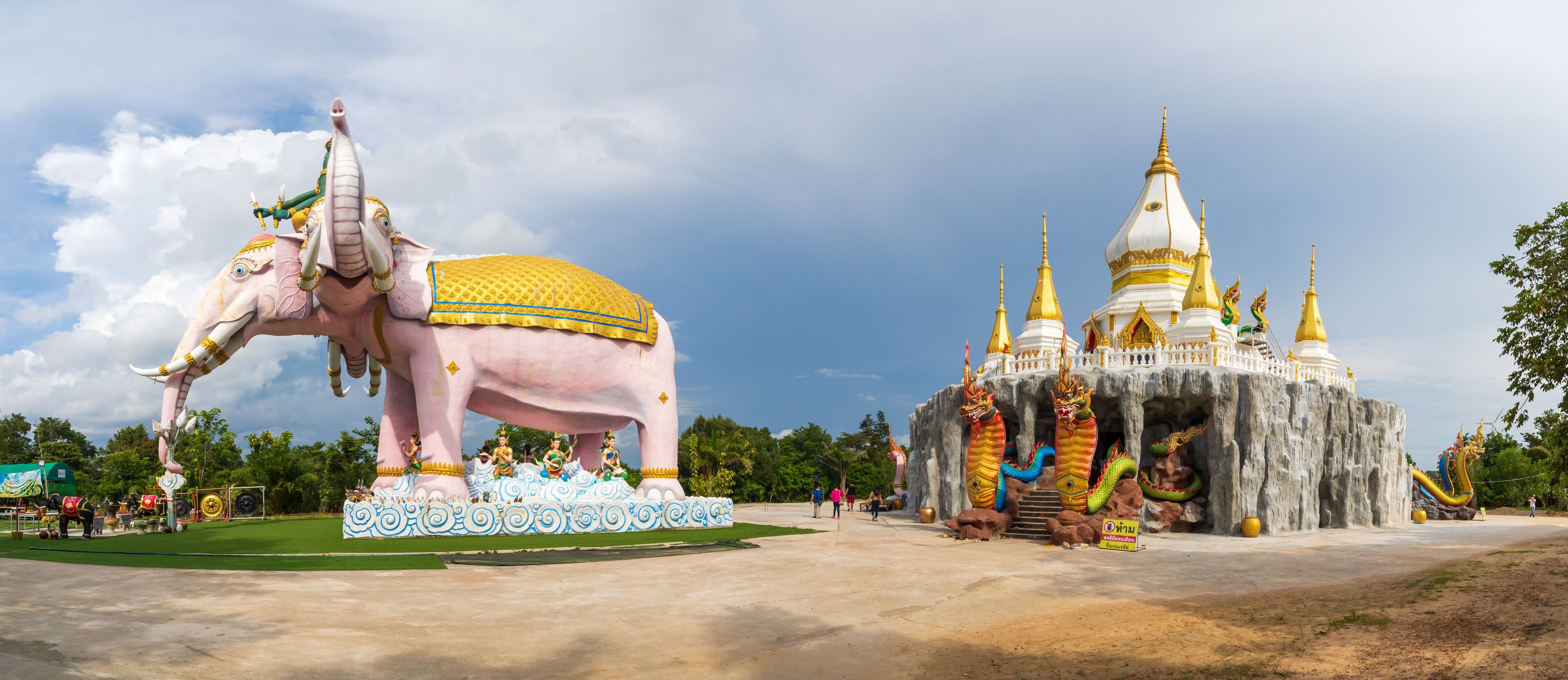 A large pink elephant statue with golden decorations, a temple with multiple spires, and a dragon statue.