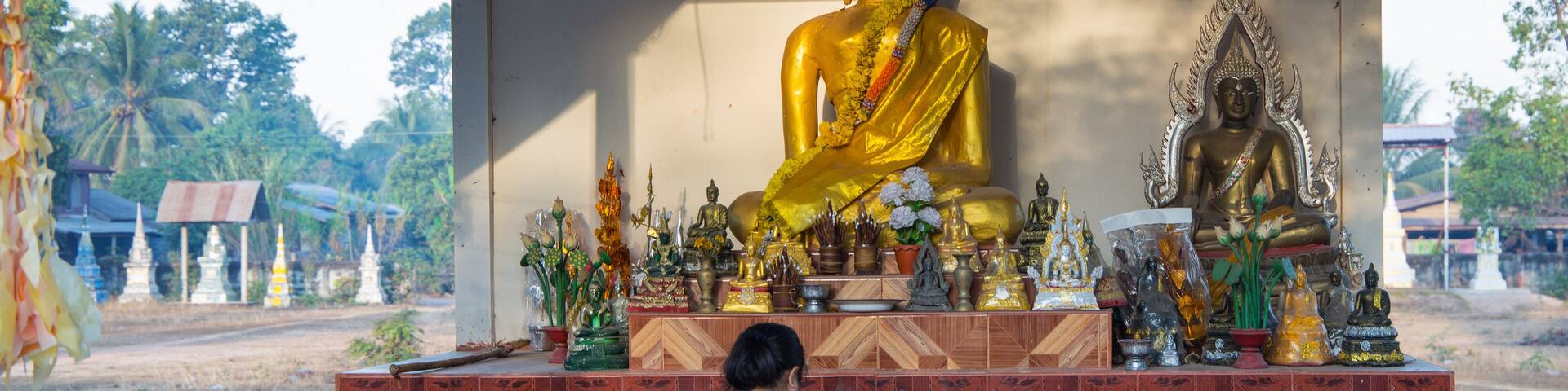 Faithful buddhist woman prays in the Akat Amnuai temple, Sakon Nakhon province, Isan, Thailand