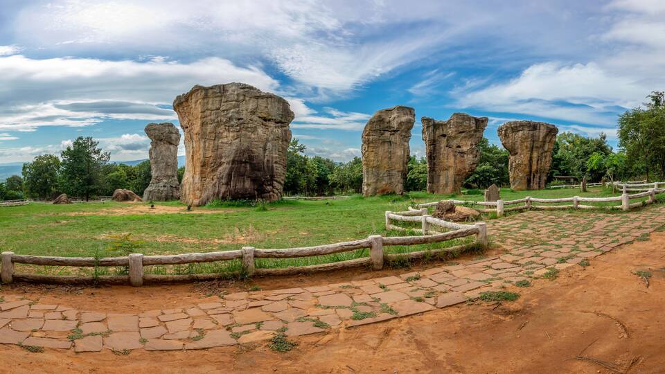 A landscape with large rock formations and a wooden fence.