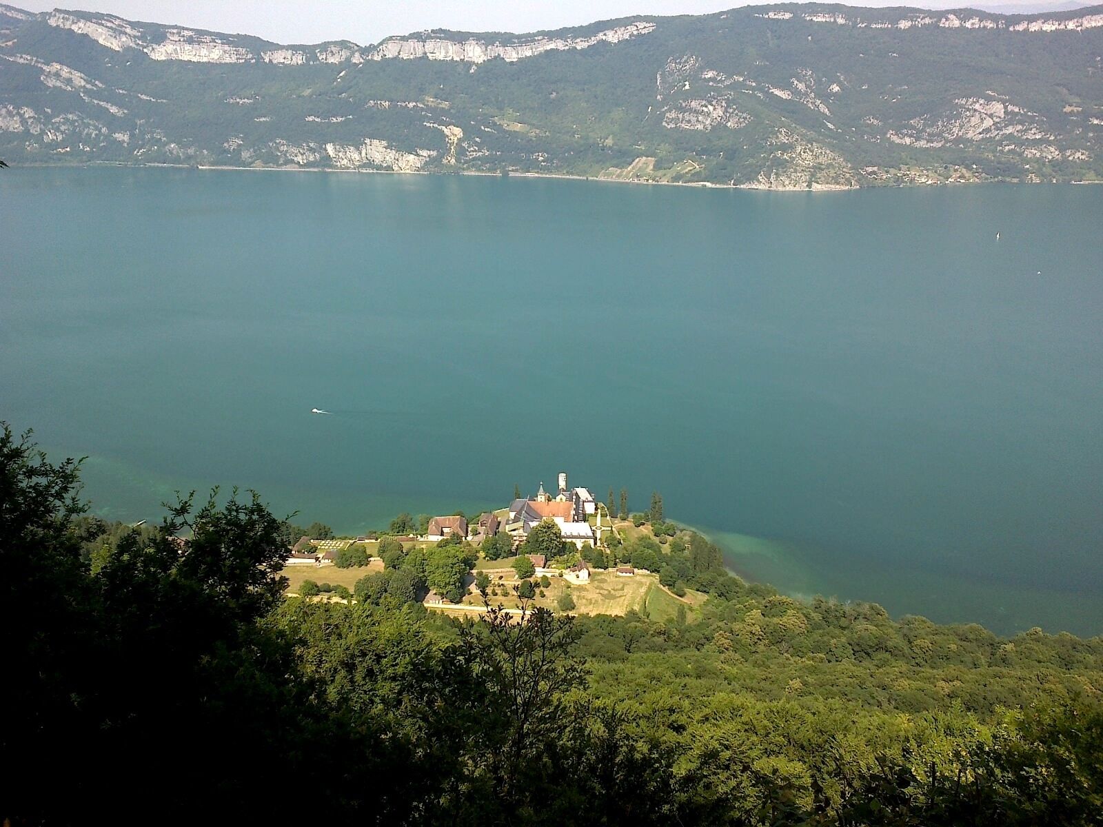 A lake surrounded by mountains and a small village with a church.