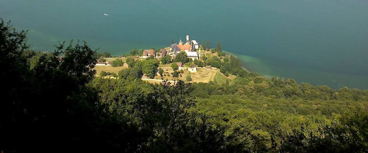 A lake surrounded by mountains and a small village with a church.