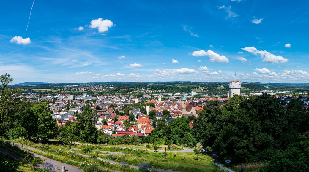 A town with red-roofed buildings, a prominent tower, and a clear blue sky.