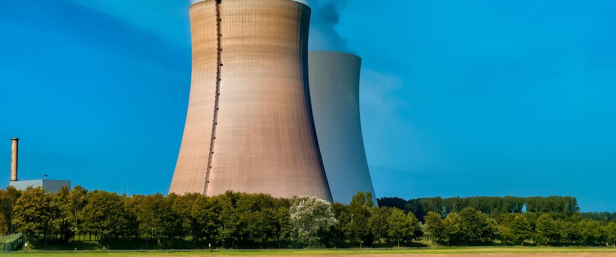 A nuclear power plant with two cooling towers emitting steam.