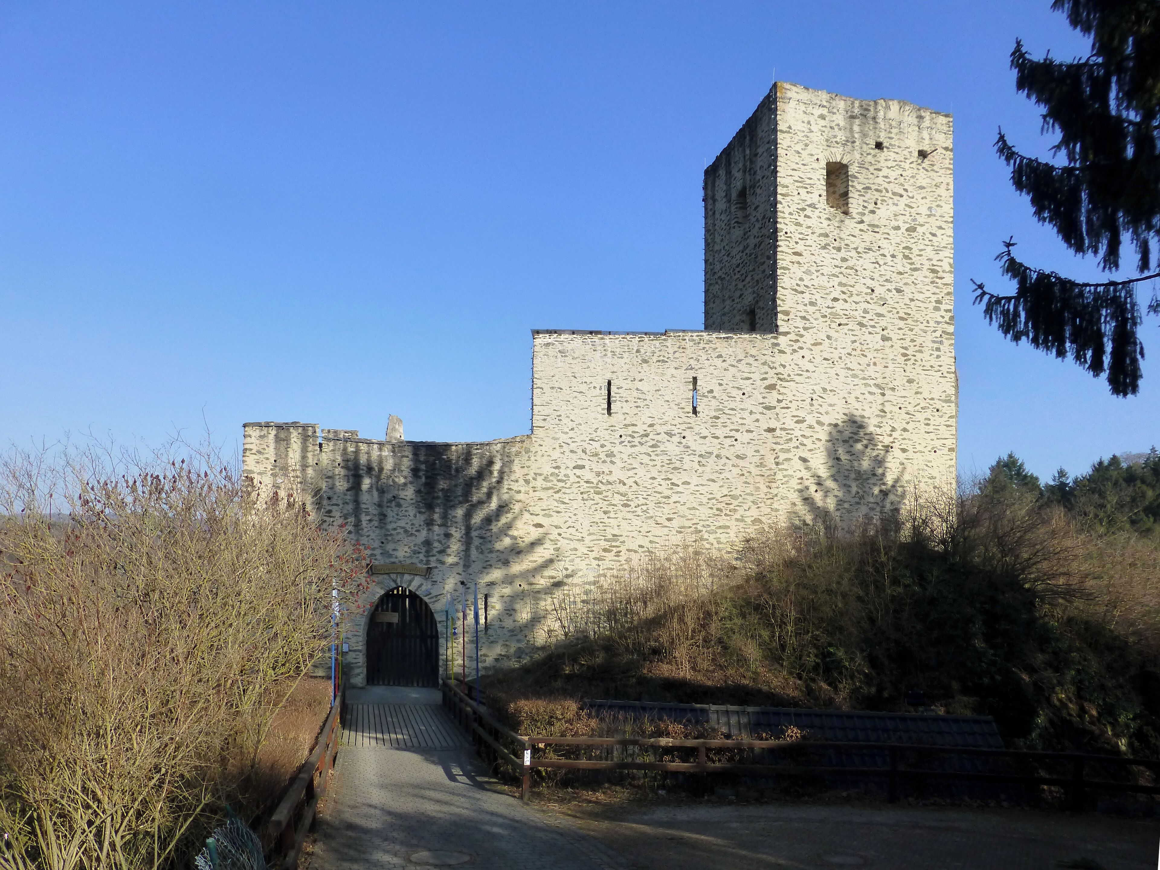 A stone castle with a tall tower and a gate.