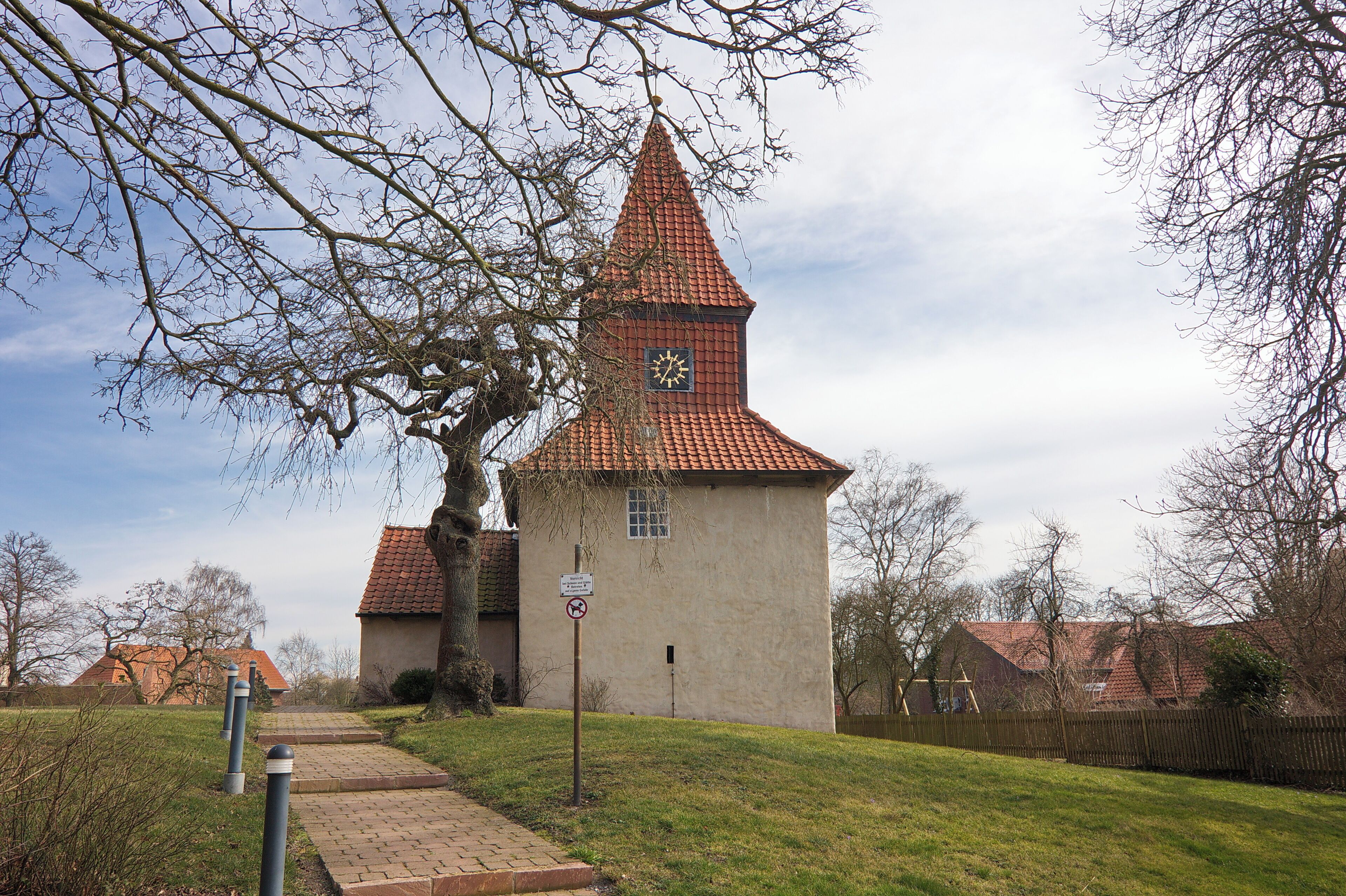 A church with a red-tiled roof and a clock tower.