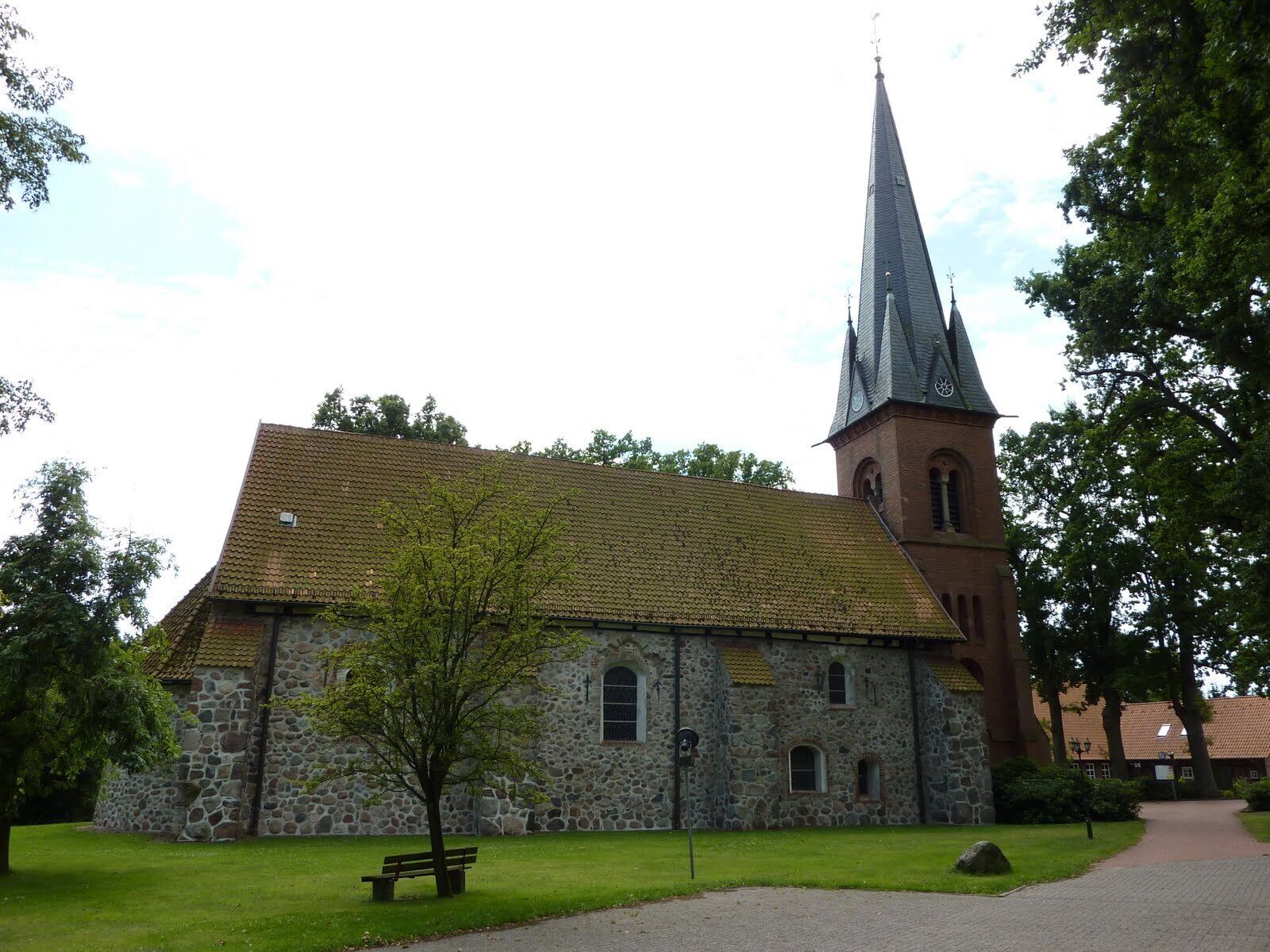 A church with a stone facade and a tall spire.