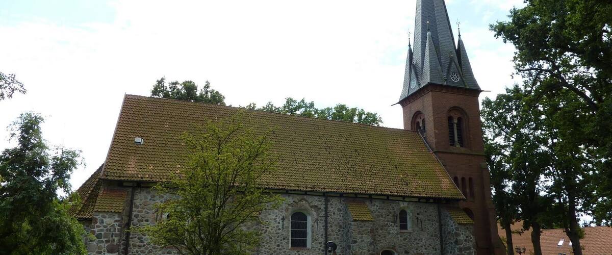A church with a stone facade and a tall spire.