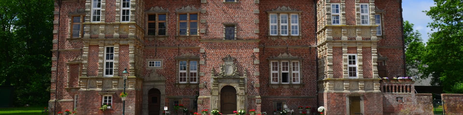 A large, historic brick building with multiple windows and a symmetrical facade.
