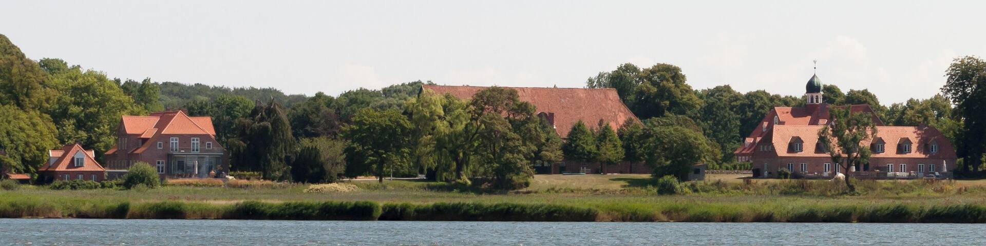 A river with houses and trees in the background.
