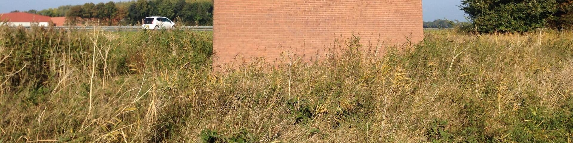 This "Monument Noordoostpolder" is a kind reminder to highway motorists about how much below sea level they are actually -safely- driving. The wave from the chimney also serves as a weather vane. - the ship is going against the currents and the wind.
Making land where the sea once was, is not supposed to be easy. #highway-art
http://www.flevolanderfgoed.nl/home/kunst/noordoostpolder/nagele/monument-noordoostpolder.html