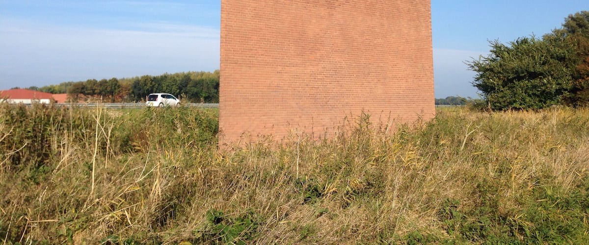 A large brick building with a chimney and a stylized ship's smokestack.