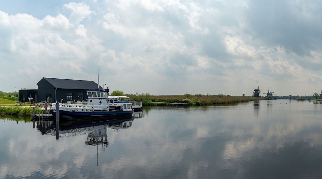 panorama view of the windmills and canals of Kinderdijk in South Holland with a dock and boat in the foreground