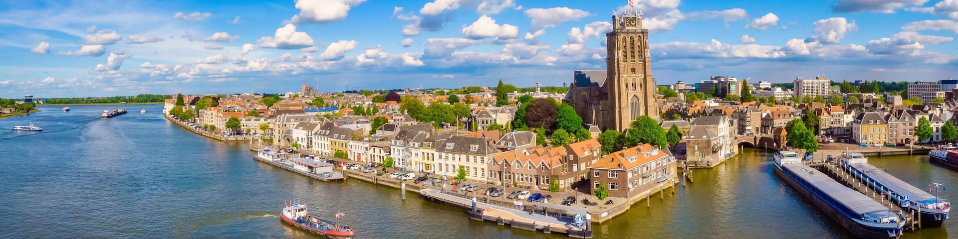 A river with boats, a prominent tower, and historic buildings along the banks.
