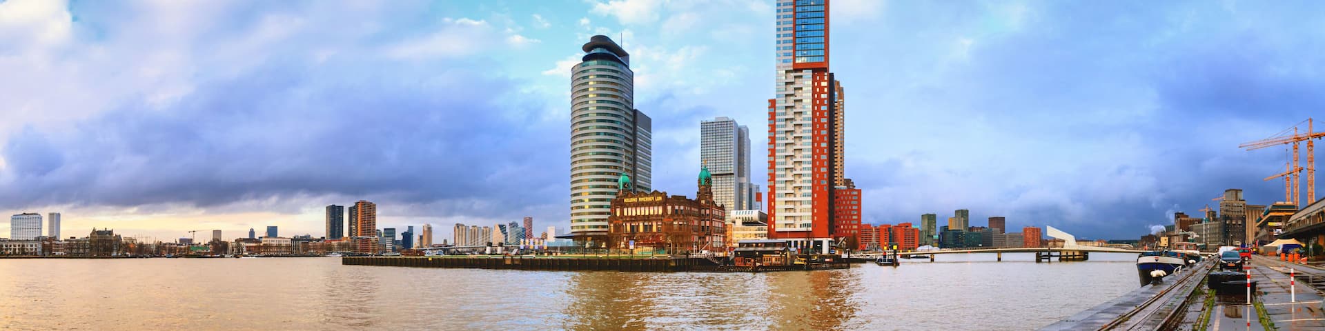 A city skyline with a prominent curved building and a tall skyscraper.