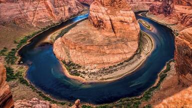 Located within a few hours drive from Las Vegas is this horseshoe shaped meander of the Colorado River. After a bit of a hike, we got to see the horseshoe bend. What an astounding beauty it was!
Also extremely nerve-wracking because it is a merciless 1000 feet drop from the canyon cliffs, and there are no rails at the edge of the cliffs. Being acrophobic made it worse! But it is an experience of a lifetime and Iโm glad I mustered all of my courage (I have very little of it), prayed all the Gods in the world (although I believe there is only God) and peeked at the formation of the horseshoe bend among the deep gorges.
To get an elaborate view of the horseshoe bend, I lay down on my stomach and literally crawled on the canyon to reach the edges. The only thing I hoped is, the cliffs were strong enough to hold my weight. And here I was, literally at the edge of a 1000 feet high cliff with my palms sweating (literally!).