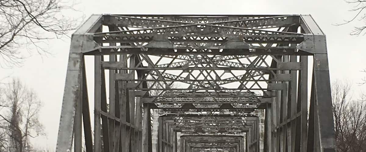 A wet, metal bridge with a yellow centerline.
