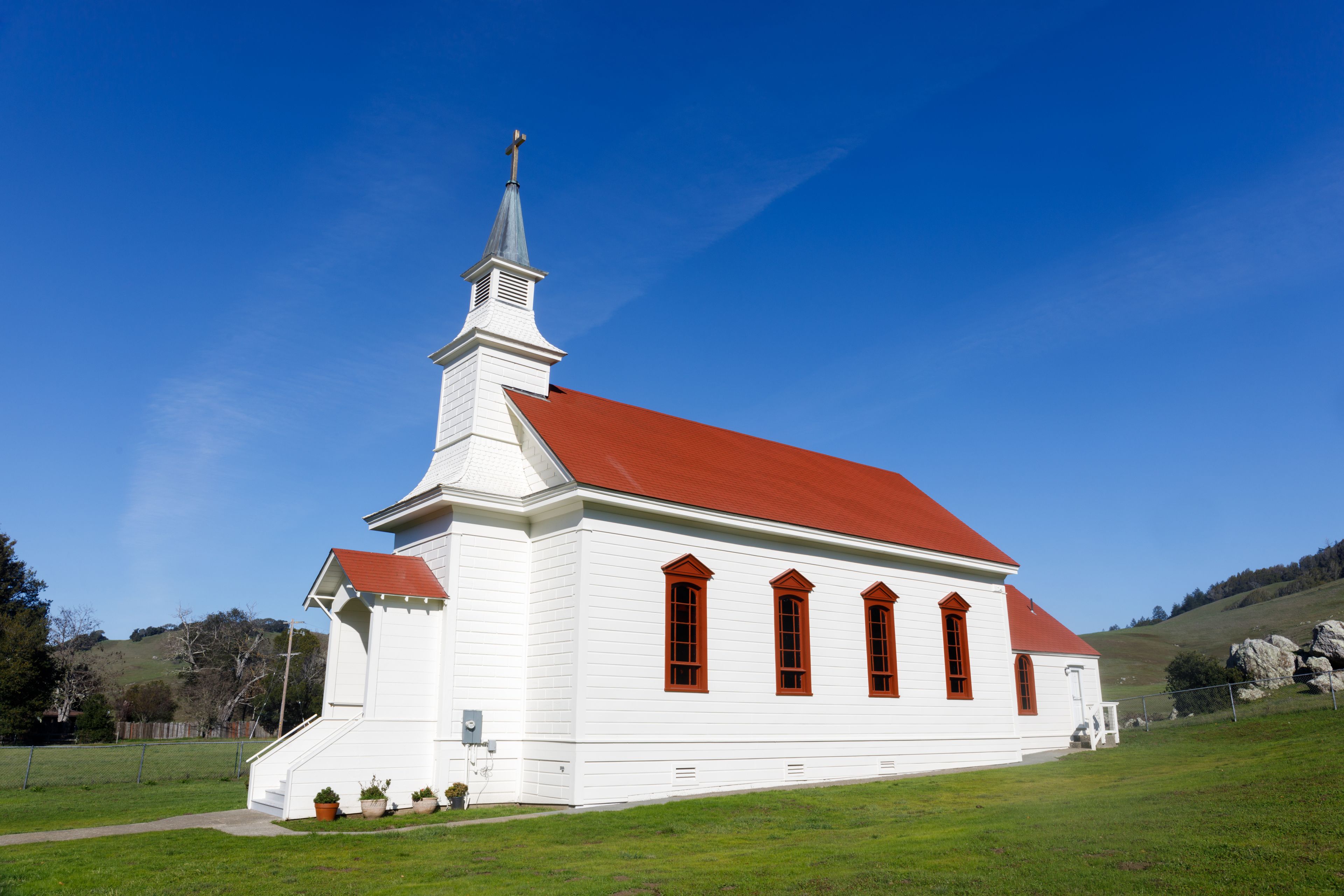 A white church with a red roof and a steeple.