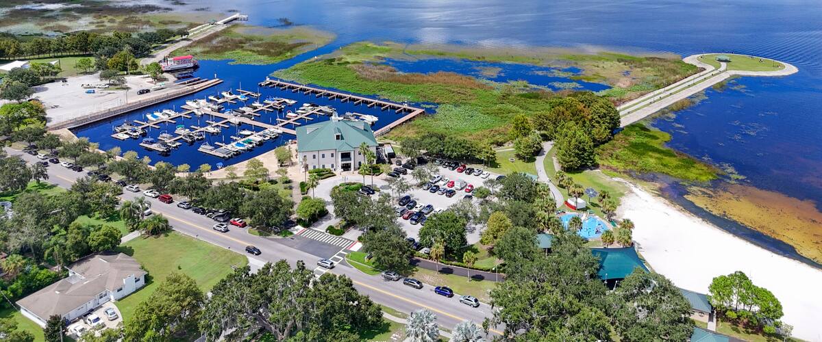 A marina with boats, a large body of water, and a bridge connecting to the mainland.