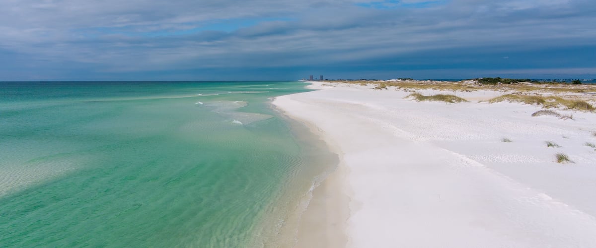 A beach with clear turquoise water and white sand.