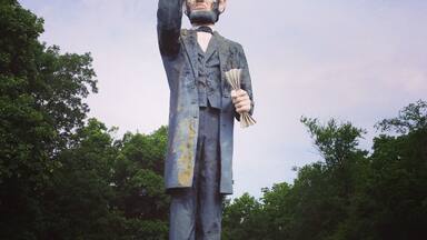 There's a small break in the chain link fence all the way to the left- near the highway. This place is closed, but this is the worlds Tallest Abraham Lincoln. That's my dog near his foot.