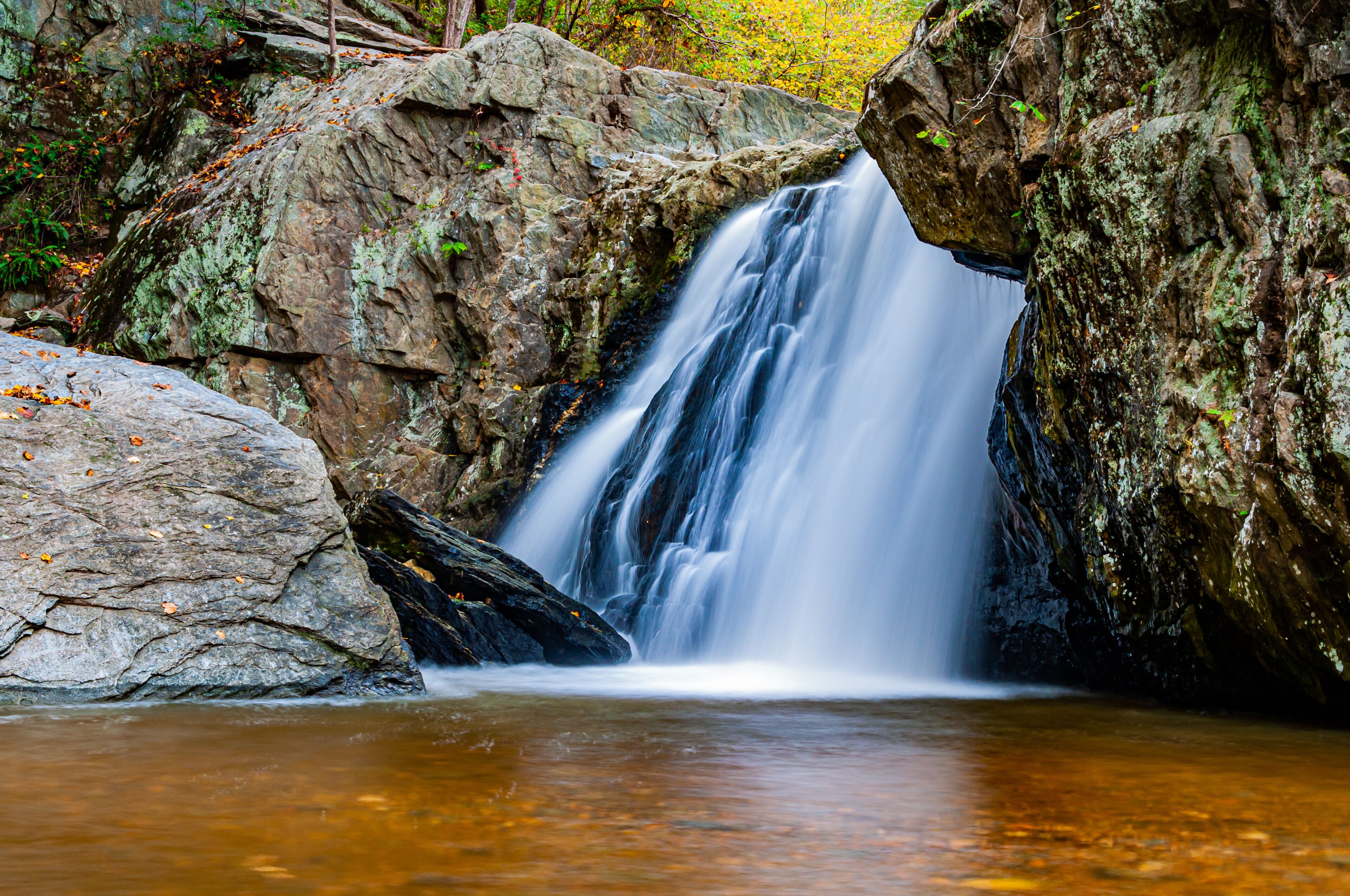 A waterfall cascading over rocks in a forested area.
