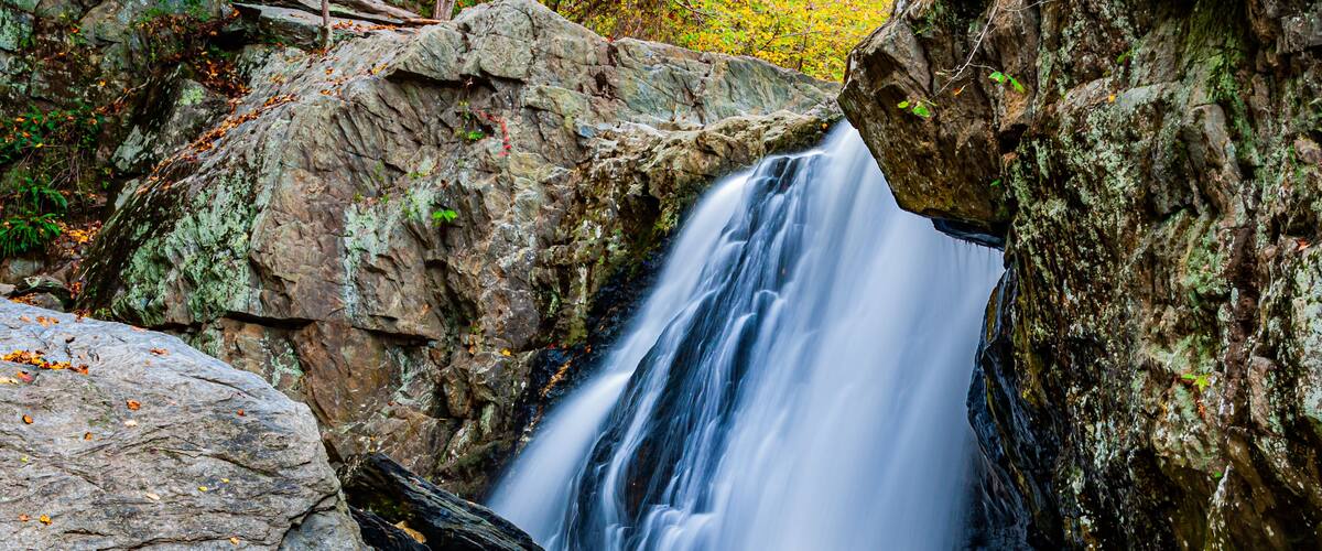 A waterfall cascading over rocks in a forested area.