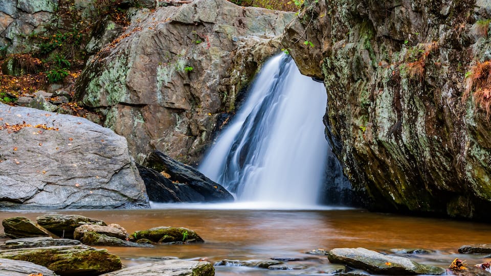 A waterfall cascading through a rocky arch.