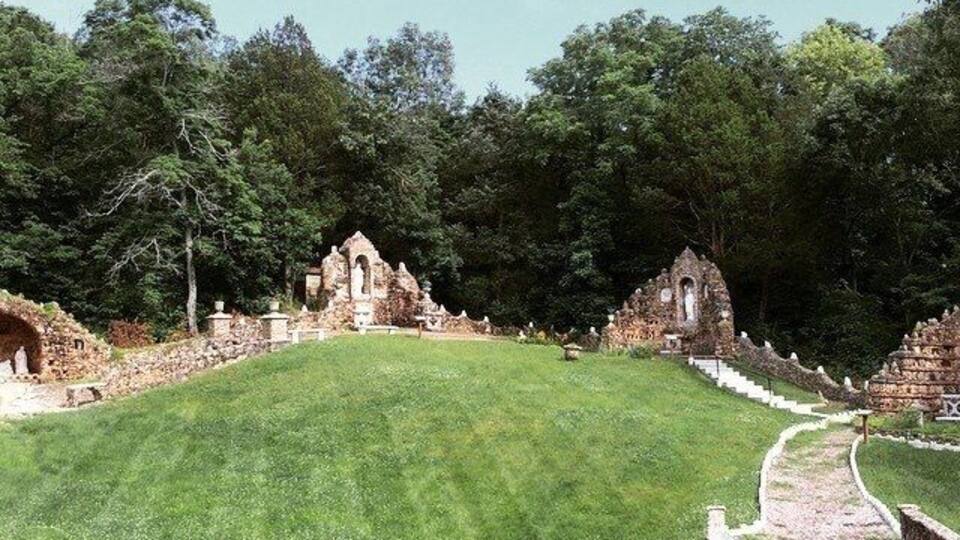 A grassy hill with ancient ruins and a stone pathway.