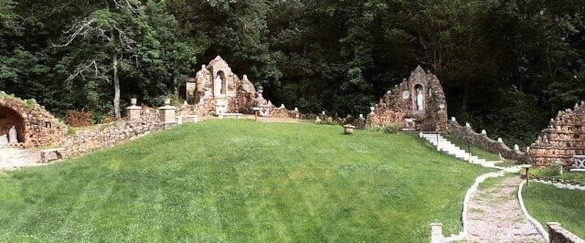 A grassy hill with ancient ruins and a stone pathway.