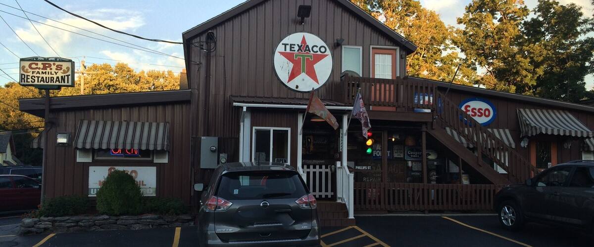 A Texaco gas station with a family restaurant, a Phillips St. repair shop, and a sign for Esso.