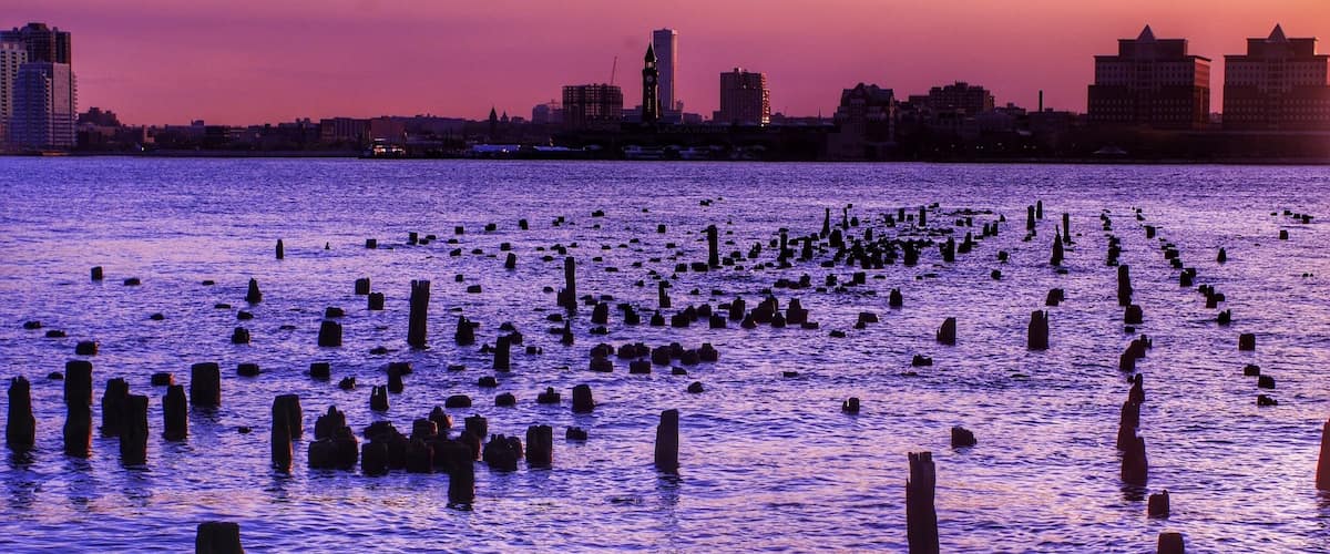 A sunset over a body of water with numerous wooden posts scattered across the surface.