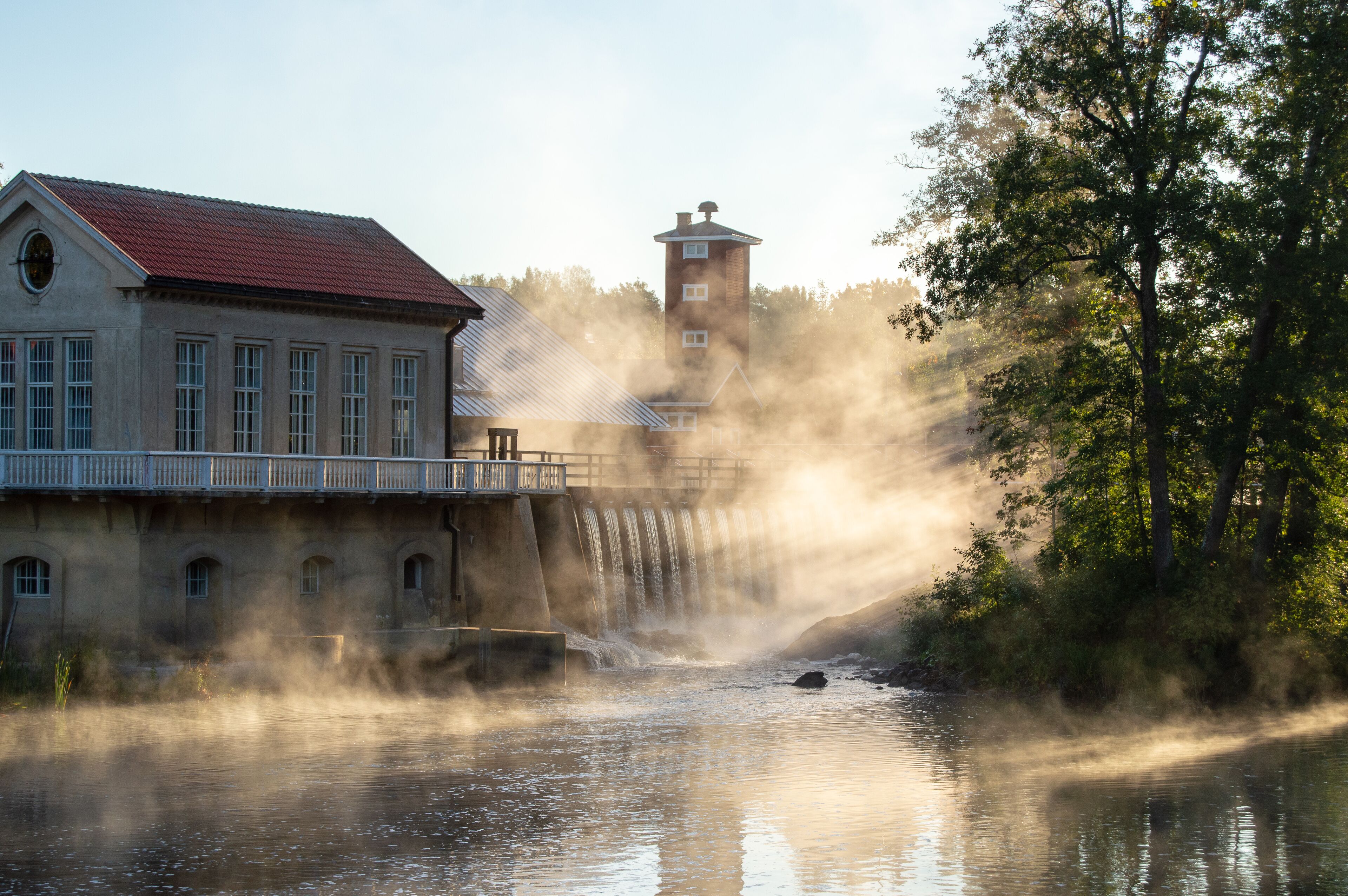 Countryside views and old watermill buildings in a misty sunrise