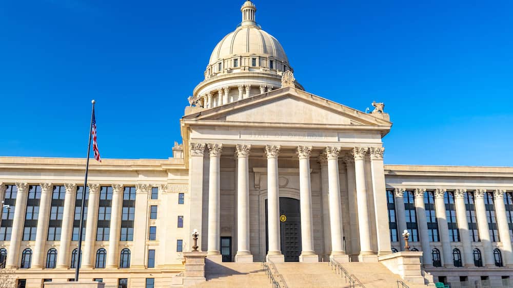 A large neoclassical building with a prominent dome and columns, likely a government or state capitol.