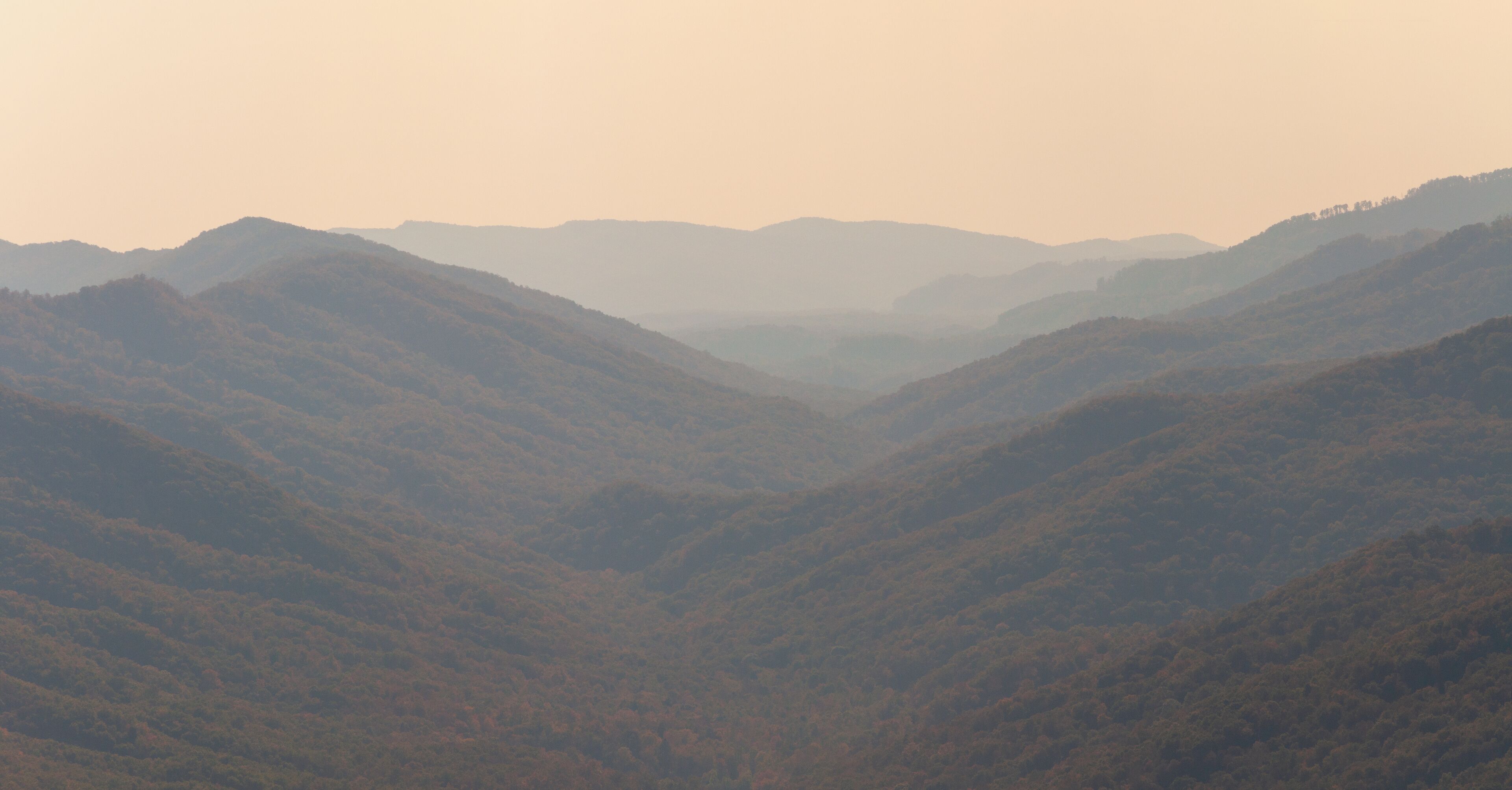 A valley with rolling hills and distant mountains.