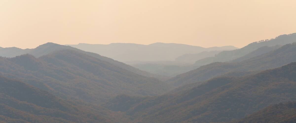 A valley with rolling hills and distant mountains.