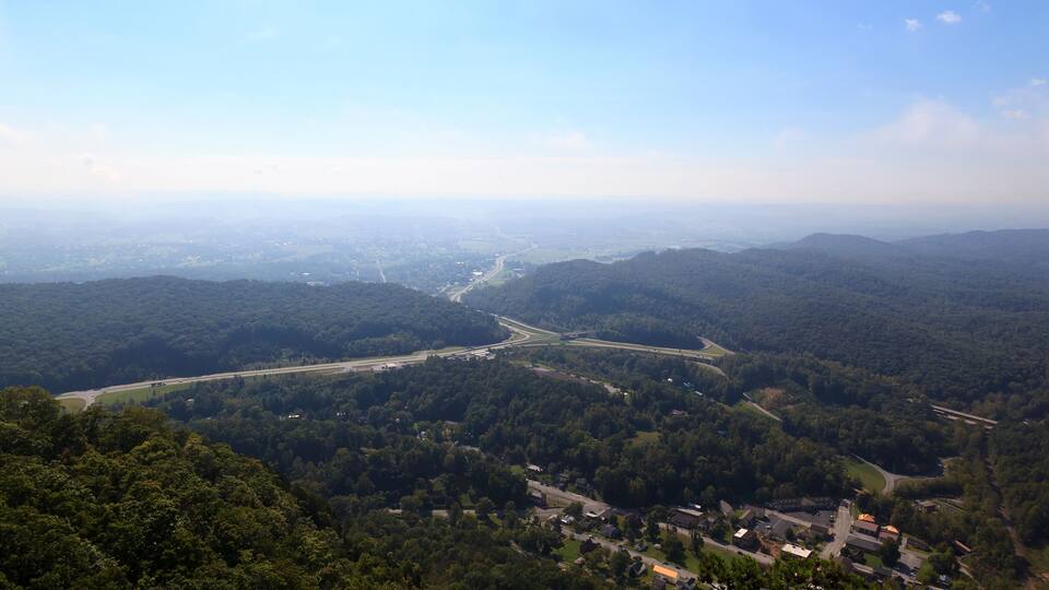 A mountainous landscape with a winding road and a small settlement.