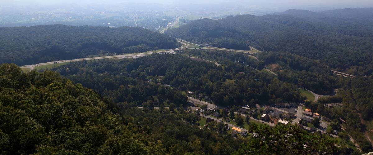 A mountainous landscape with a winding road and a small settlement.
