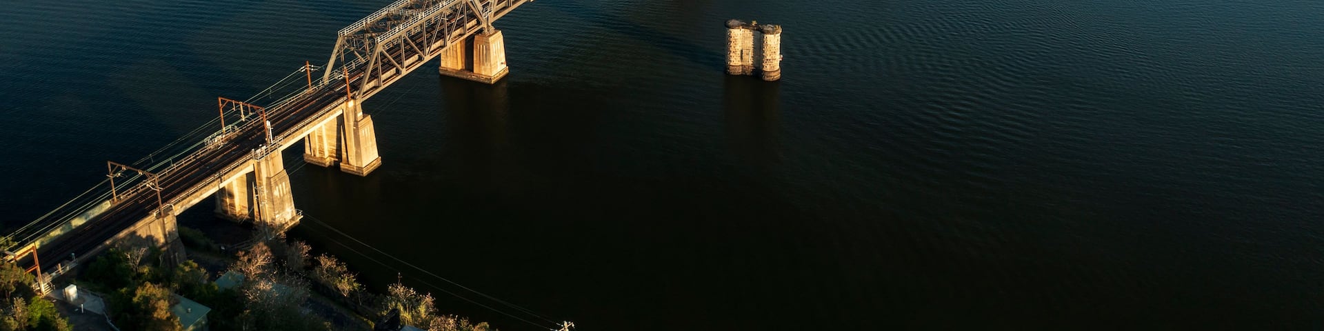 A large steel bridge spanning a wide river with multiple supports.