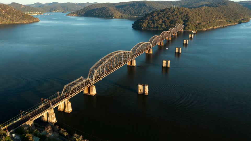 A large steel bridge spanning a wide river with multiple supports.