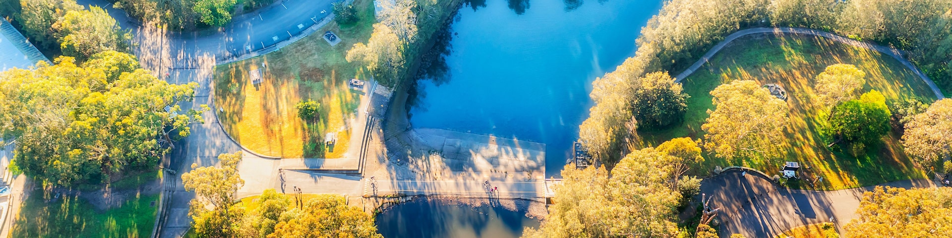 Une vue aérienne d’un parc avec un lac, des routes sinueuses et une végétation dense.