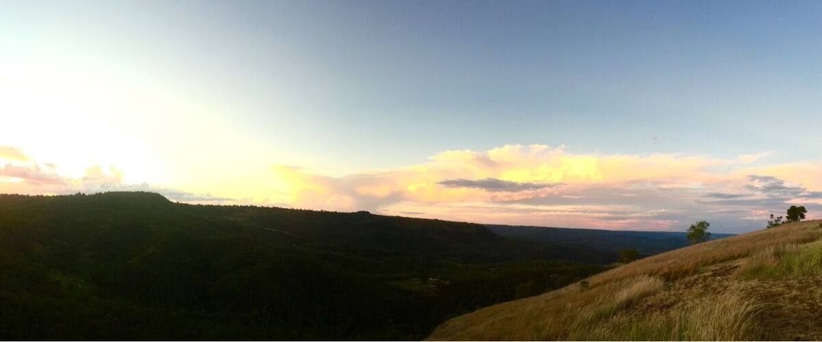 A landscape with rolling hills and a sunset.