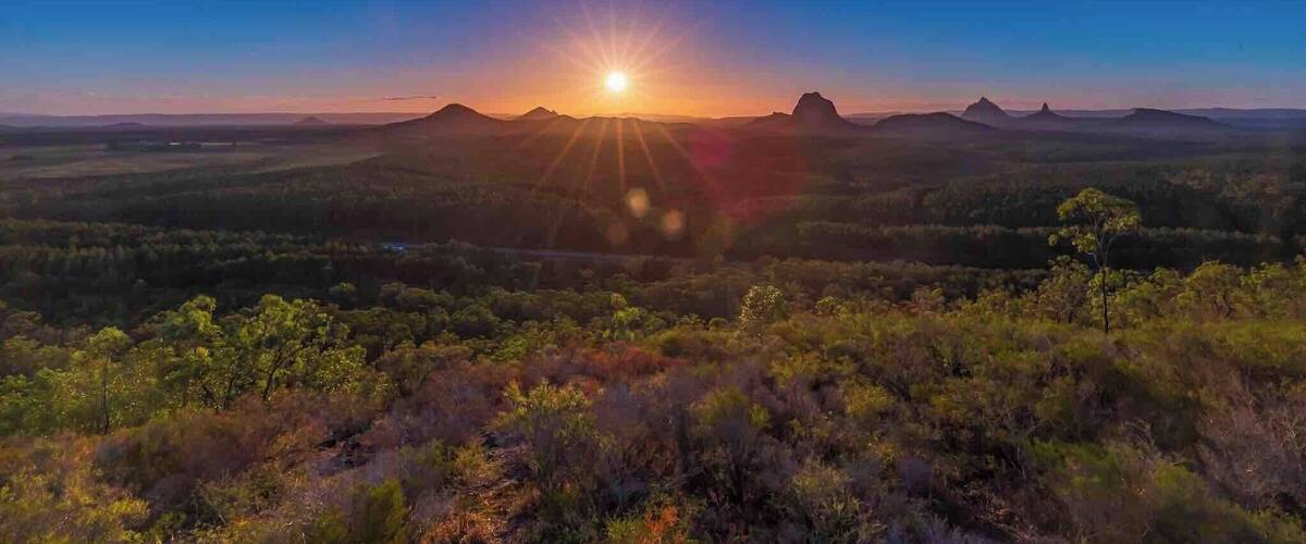 A sunset over a mountainous landscape with a clear sky.
