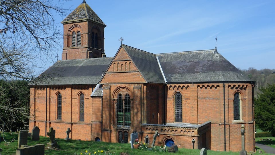 A church with a bell tower and a cemetery in front.