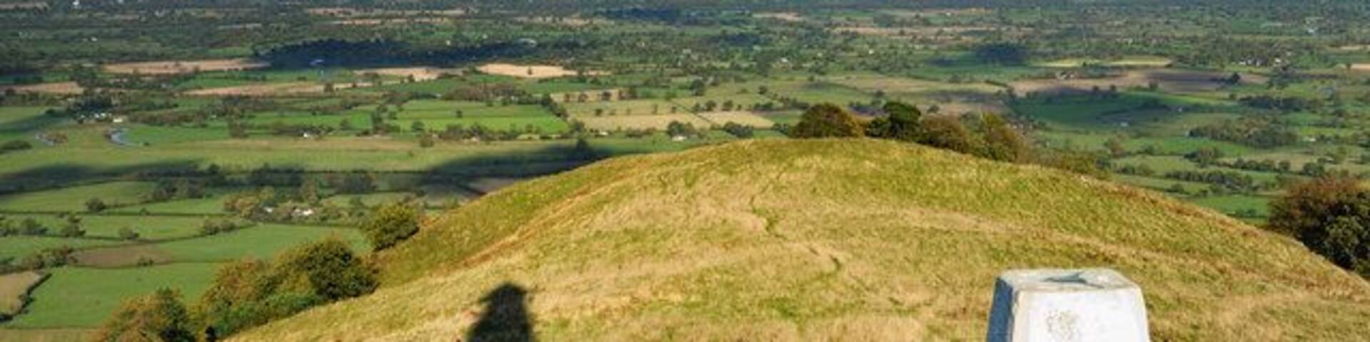 In the shadow of a hero Here we have another perception of Rodneys Pillar atop Breidden Hill, with the trig point in the foreground.