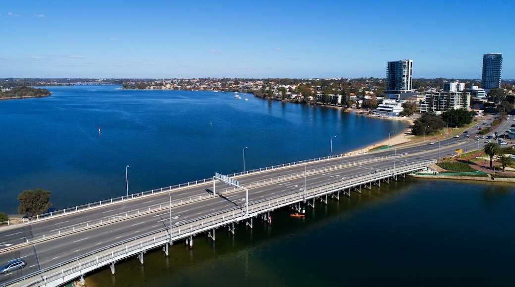 Un pont enjambant une étendue d’eau importante, avec une vue sur la ville en arrière-plan.