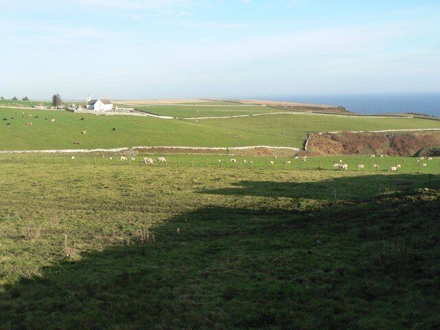 Latheron: fields and sea view on the A9 Looking east from the A9 near the main junction at Latheron. The old church, now a museum, is also visible.