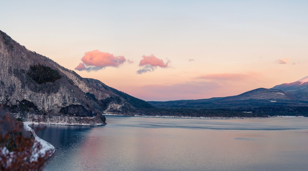 Ein Berg mit einem See im Vordergrund und einem klaren Himmel.